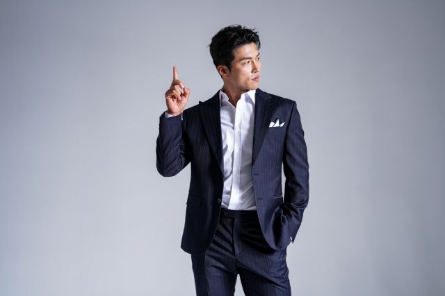 人差し指を上に向ける男性